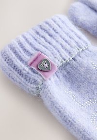 Fioletowy dzianinowy mankiet rękawiczki z ściągaczem, różowa aksamitna łata i srebrny guzik w kształcie serca z wygrawerowanym napisem.