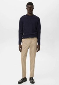 Marineblauer Strickpullover, einfarbige beigem Slim-Fit-Hose und schwarze Lederschuhe. Einfaches Design, glatte Textur und taillierte Passform.