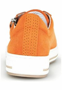 Sneaker en daim orange avec une semelle en caoutchouc blanc, présentant un panneau arrière texturé et des coutures d'accent. Détail de zip sur le côté.