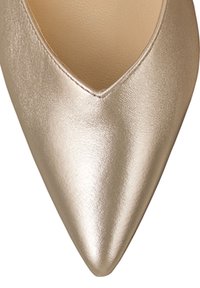 Chaussure à bout pointu en or métallique avec une texture lisse, présentant une découpe en V sur le dessus. Un éclat subtil rehausse son design.