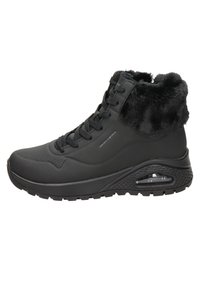 Baskets montantes noires avec upper texturé imperméable, col en fourrure, fermeture à lacets à l'avant et semelle avec coussin d'air visible.