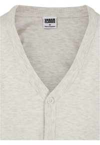 Cardigan gri deschis cu un design în formă de V, având un singur nasture la închidere, textură împăturită la guler și în față, și etichetă de marcă la gât.