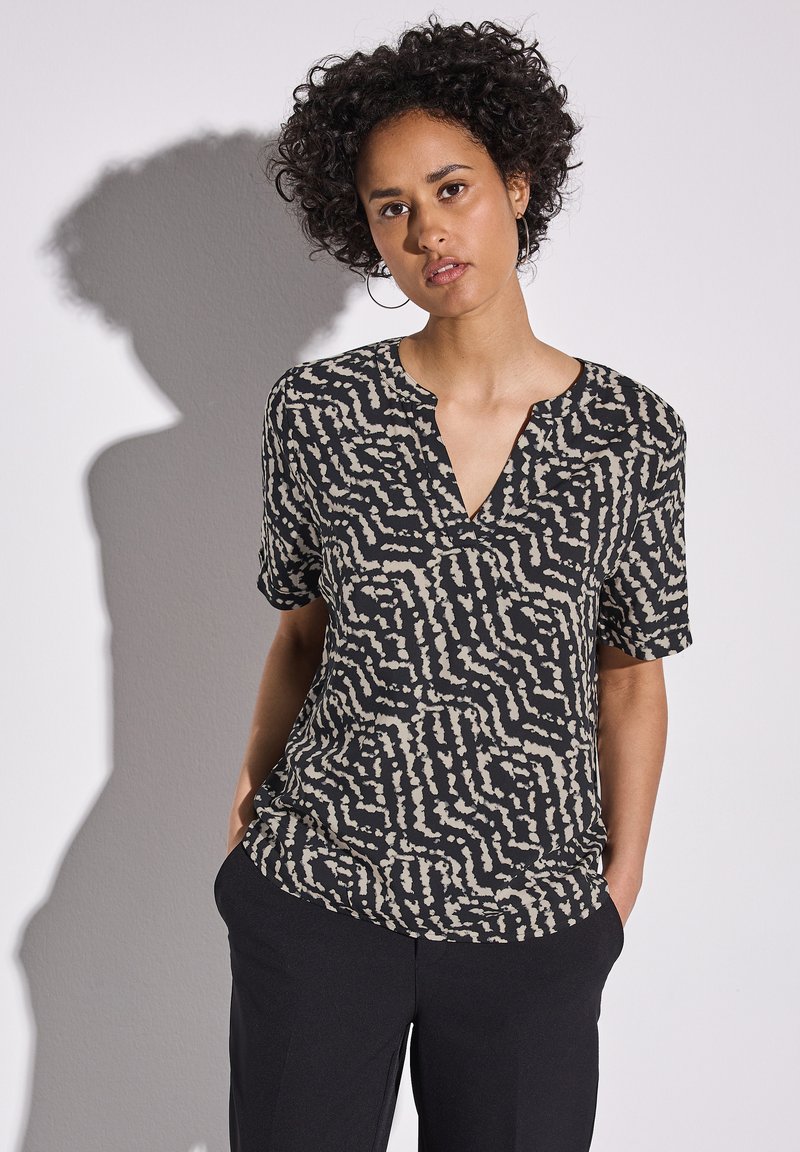 Schwarzes T-Shirt mit kurzen Ärmeln und einem abstrakten Muster in Creme und Beige, mit V-Ausschnitt und lockerer Passform, aus leichtem Stoff gefertigt.