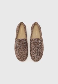 Sko med leopardmønster og snøring laget av mykt materiale; brun bunn med svarte flekker; avrundet tå; kontrastfargede sømmer og hull for snøringen.
