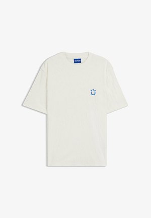 Hvid kortærmet T-shirt med en blå Hugo-logoetiket ved kraven og et lille blåt smiley-ansigt på venstre bryst.
