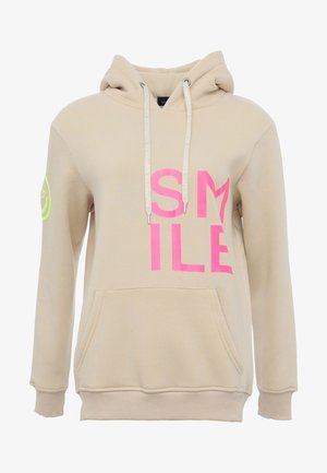 Beige hoodie with a large pink "SMILE" print on the front, drawstrings, front pocket, and a circular logo in green on the left sleeve.