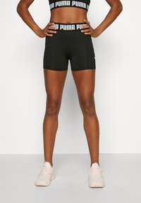Black athletic shorts with a fitted design, featuring a PUMA logo waistband. Soft, stretchy fabric with flat seams for comfort.