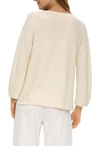 Cremfarbener Pullover mit strukturiertem Finish, weit geschnittenen Ärmeln und entspannter Passform. Verfügt über einen runden Halsausschnitt und einen genähten Saum.