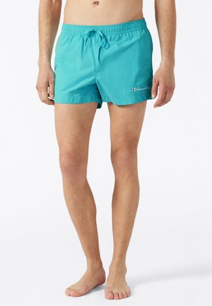 Costumi da bagno turchesi con vita elastica e cordino. Realizzati in materiale leggero, presentano un piccolo logo sul lato.