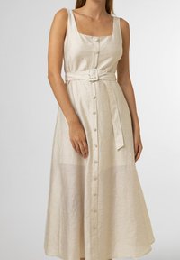 Béžové lněné midi šaty se čtvercovým výstřihem, zapínáním na knoflíky vpředu a páskem. Mají strukturovaný povrch a splývavý střih.