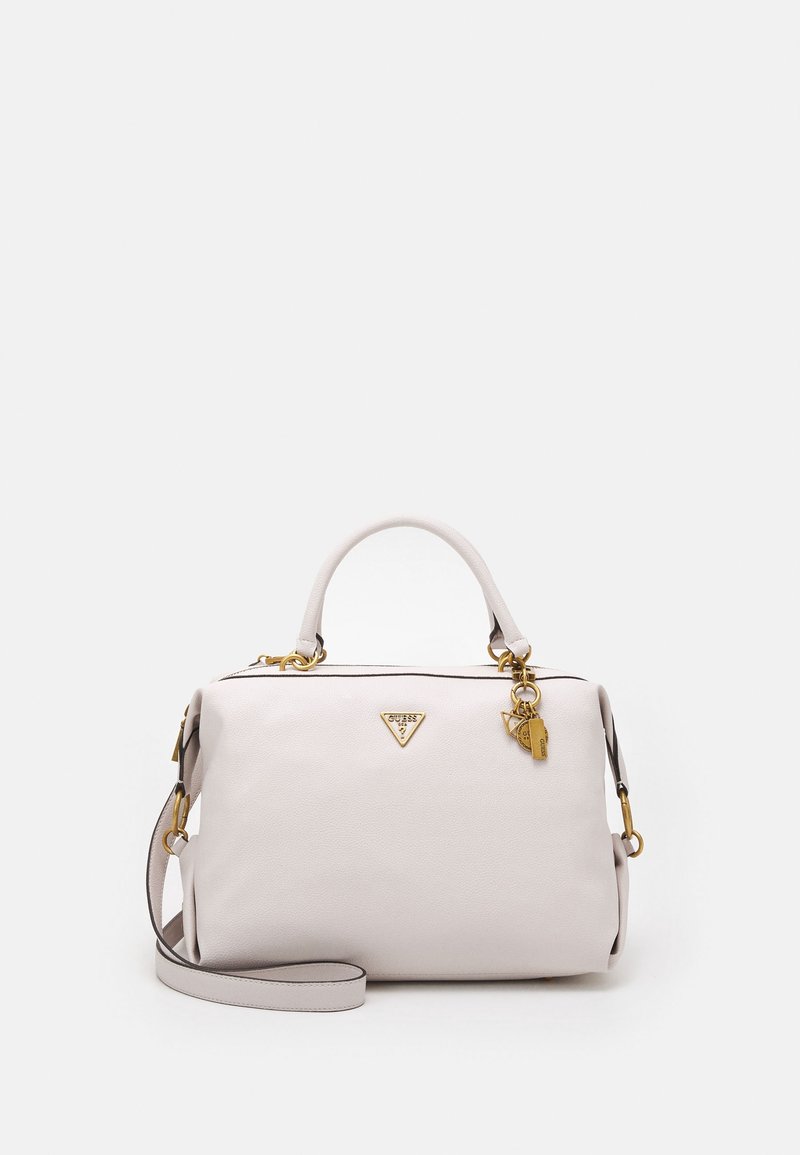 Jasnoszara skórzana torebka z złotymi detalami, górnym uchwytem, odpinanym paskiem na ramię i wiszącymi ozdobnymi charmsami na jednolitym tle.
