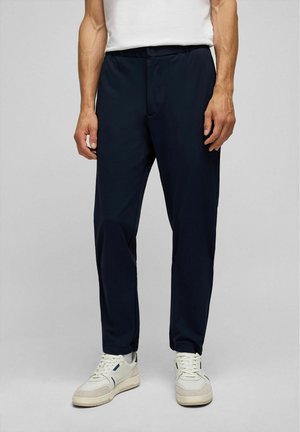 Marineblauwe broek van een lichtgewicht, glad materiaal. Elastische tailleband met een knoopsluiting, taps toelopend ontwerp van de benen en zijzakken.