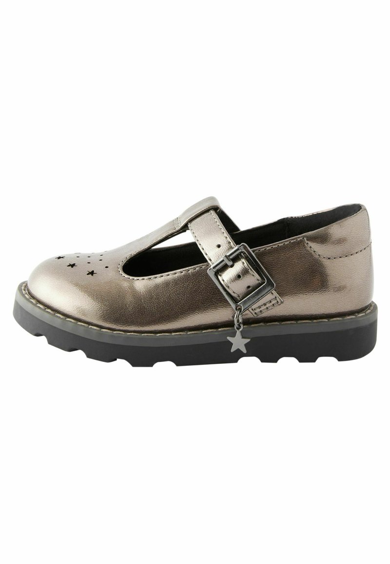 Metallic silberne T-Bar-Schuhe mit perforiertem Sternmuster, Schnallenriemen, schwarzer Gummisohle und Sternanhänger-Detail. Flach mit runder Zehenpartie.