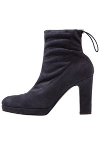 Bottine en daim noir avec talon haut carré, bout rond et languette élastique à l'arrière.