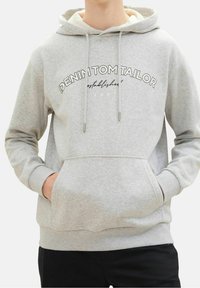 Světle šedá mikina z bavlněné směsi. Obsahuje přední kapsu, kapuci se stahovací šňůrkou a potištěný text "DENIM TOM TAILOR založen 2007".