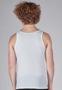 White, sleeveless tank top made from a soft, lightweight fabric. Features a rounded neckline and is form-fitting with minimal seams.