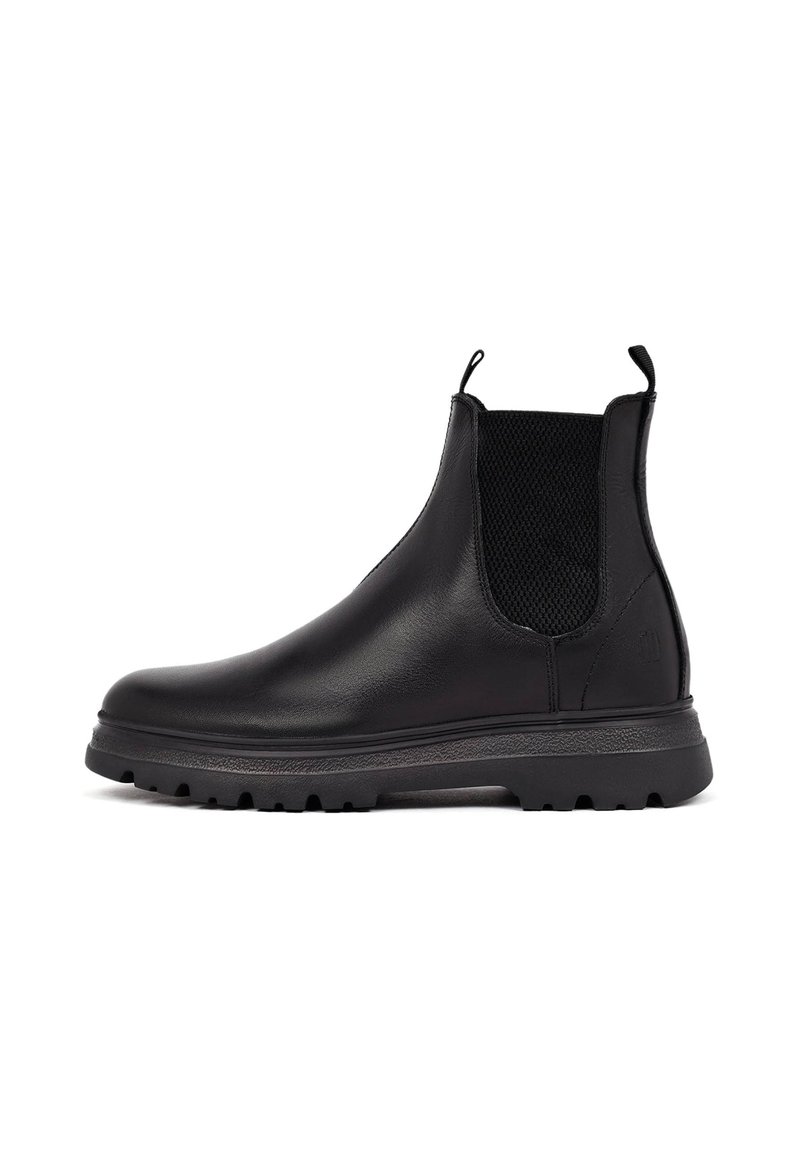 Botas Chelsea de cuero negro con paneles laterales elásticos, suela de goma texturizada, lengüetas en el talón y un diseño elegante para un uso fácil.
