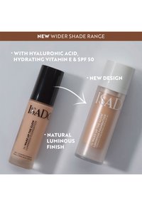 Liquid foundation in two bottles: a matte black bottle and a frosted white bottle. Both feature sleek designs with labels.