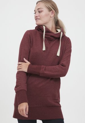 Sweat-shirt à capuche bordeaux en tissu doux, avec un col cheminée et des cordons beiges, des manches longues, et un ourlet arrière légèrement plus long.