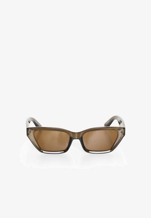 Aurinkolasit, joissa on geometrinen muotoilu, läpikuultava harmaa runko, ruskeat sävytetyt linssit ja tukevat sankat. Ominaisuutena on voimakas kulmakarvaviiva.