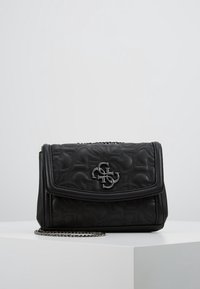 Black quilted handbag with a silver logo emblem. Features a folded flap and a chain strap, showcasing a smooth texture and compact design.