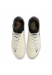 Scarpe da calcio bianche con superficie testurizzata, risvolto nera alla caviglia e logo Nike nero. Presentano motivi circolari e lacci a contrasto.
