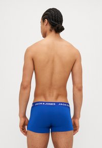 Blaue Boxershorts aus einem weichen Stoff, mit einem weißen Bund, auf dem die Marke "JACK & JONES" wiederholt zu sehen ist. Die Ansicht zeigt die Rückseite.