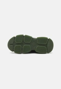 Suela de zapatilla de goma en verde oscuro con patrón de agarre texturizado, que presenta una punta redondeada y distintivas crestas de tracción para mayor estabilidad.