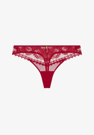 Culotte en dentelle rouge avec motifs floraux et un petit pendentif décoratif doré au centre devant, présenté sur un fond blanc.