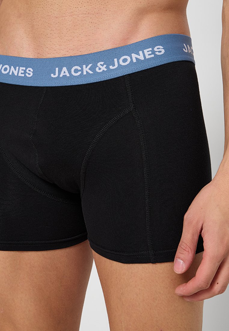 Schwarze Baumwollboxershorts mit einem blauen elastischen Bund, auf dem "JACK & JONES" in weißem Text steht. Glatte Textur und figurbetontes Design.