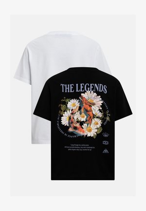 Svart t-skjorte med tusenfryd, koi-fisker og teksten "THE LEGENDS", lagdelt over en enkel hvit t-skjorte.