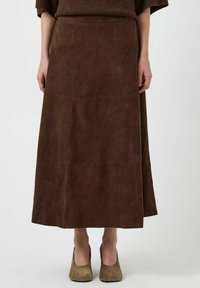 Gonna maxi in suede marrone con cuciture verticali, caratterizzata da una vestibilità rilassata e una trama liscia, abbinata a tacchi alti in suede marrone.