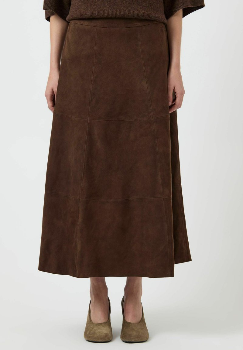 Gonna maxi in suede marrone con cuciture verticali, caratterizzata da una vestibilità rilassata e una trama liscia, abbinata a tacchi alti in suede marrone.