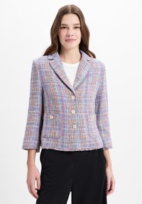 Tweedjasje in pasteltinten met een ruitpatroon, voorzien van een geknipt revers, dubbelgeknoopte knopen en een franjes onderrand.