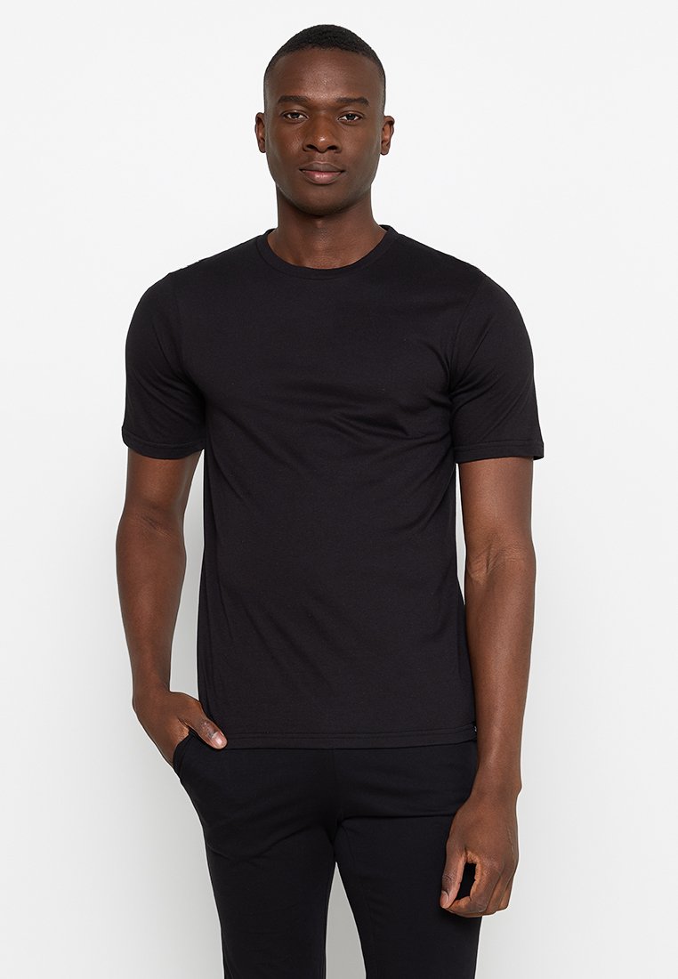 Camiseta corta negra de algodón, con cuello redondo y una textura suave, diseñada para una silueta ajustada.