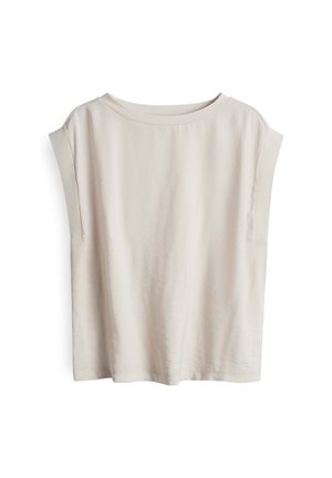 Haut à manches courtes de couleur beige clair, fabriqué en tissu doux, avec un large col et des coutures d'épaule tombantes, offrant une coupe décontractée et un design minimaliste.