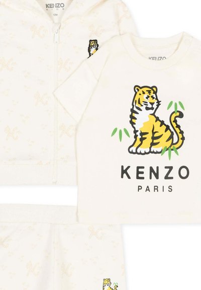 Crèmekleurige babyoutfit met tijgerprint en KENZO PARIS-logo op het T-shirt, bijpassend jasje en broek met subtiel patroon.