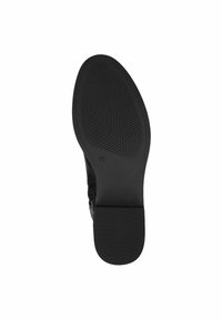 Semelle de chaussure noire avec une surface texturée présentant un motif en diamant. Bords lisses et un léger talon. Matériau en caoutchouc pour la durabilité.