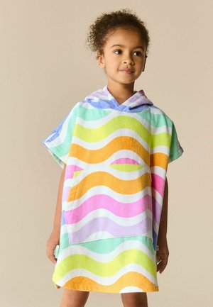 Jong kind dat een kleurrijke hooded towel poncho draagt met golvende strepen in oranje, roze, groen en blauw tegen een effen beige achtergrond.