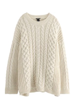 Cremefarvet strikket sweater med kabeldesign, rund halsudskæring og dropped shoulders. Den teksturerede stof giver visuel interesse.