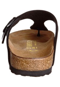 Sandalo in suede nero con sottopiede in sughero. Presenta una base imbottita, un cinturino posteriore e una suola testurizzata per una maggiore aderenza. Iscrizione visibile all'interno.