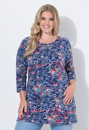 Tunic blu con maniche a 3/4, caratterizzato da un motivo floreale in rosso, rosa e verde. Tessuto morbido, scollatura arrotondata e design di lunghezza media.