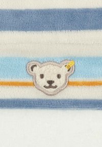 Pruhovaný ručník s měkkou texturou v modré, bílé a oranžové barvě. Obsahuje výšivku medvědí tváře se šedými obrysy a žlutým akcentem.