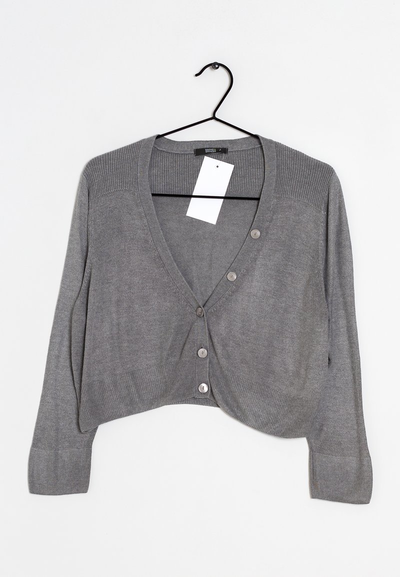 Cardigan gris raccourci à boutons avec manches longues suspendu sur un cintre noir, avec un col et des poignets côtelés, et une étiquette de prix blanche.