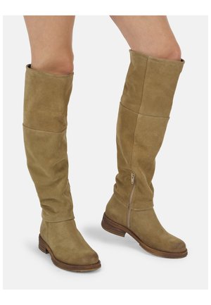 Hellbraune kniehohe Wildlederstiefel mit niedrigen Holzabsätzen und seitlichen Reißverschlüssen, getragen an nackten Beinen.
