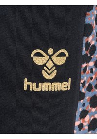 Schwarzer Stoff mit einem goldenen Logo, das ein Bienendesign und das Wort "hummel" zeigt. Akzentuiert mit farbenfrohen Leopardenmuster.