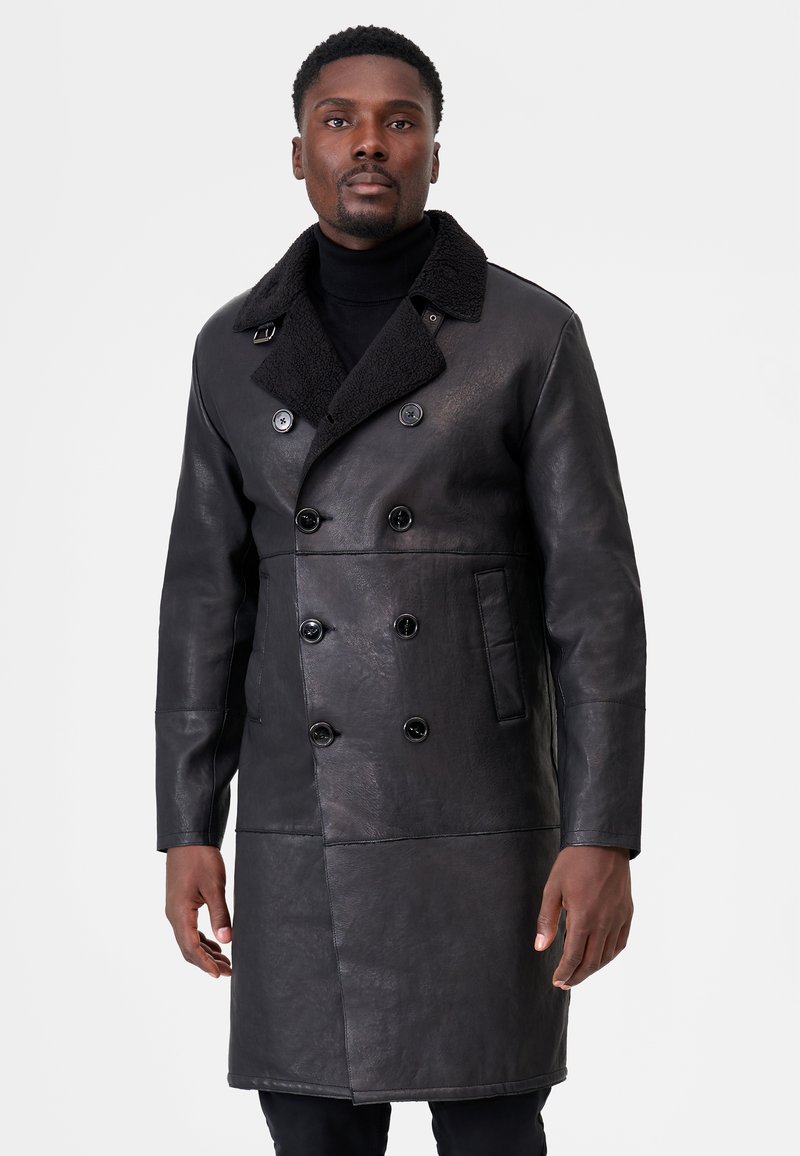 Black leather double-breasted coat with a textured collar, featuring large buttons, side pocket, and a tailored fit. Smooth, shiny finish.