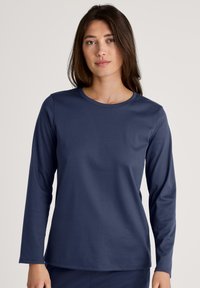 Navy long-sleeve top in soft fabric with a crew neckline. Features a relaxed fit and smooth texture, suitable for layering or casual wear.