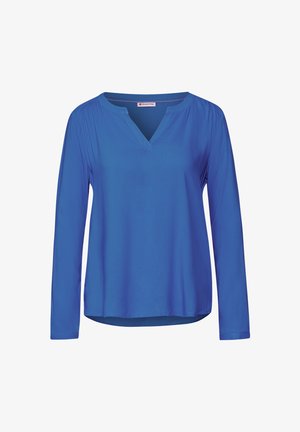Chemise à manches longues de couleur bleu vif, avec un décolleté en V, une texture lisse et un léger ruissellement aux épaules.