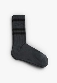 Chaussettes grises avec un design côtes, présentant des rayures noires et un logo. Matériau doux, longueur mi-mollet, et zone des orteils renforcée.